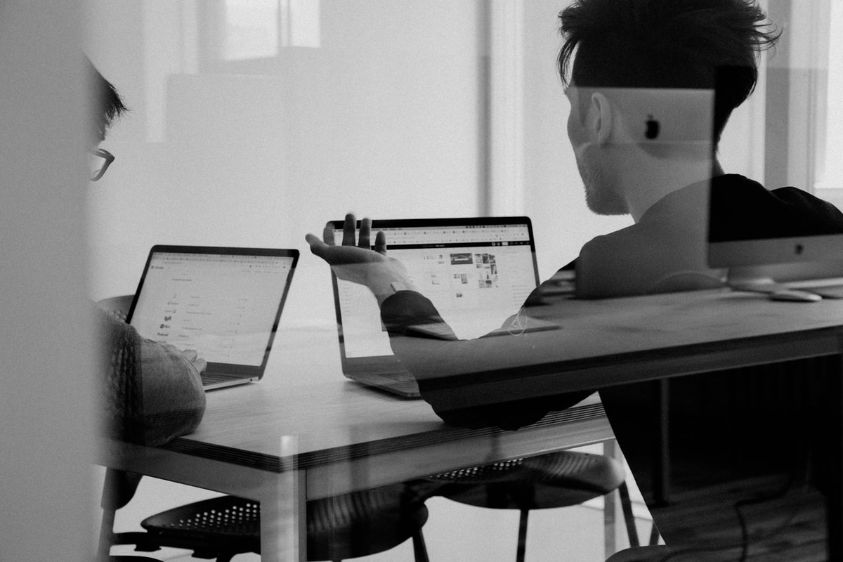 Two people reviewing work on a laptop